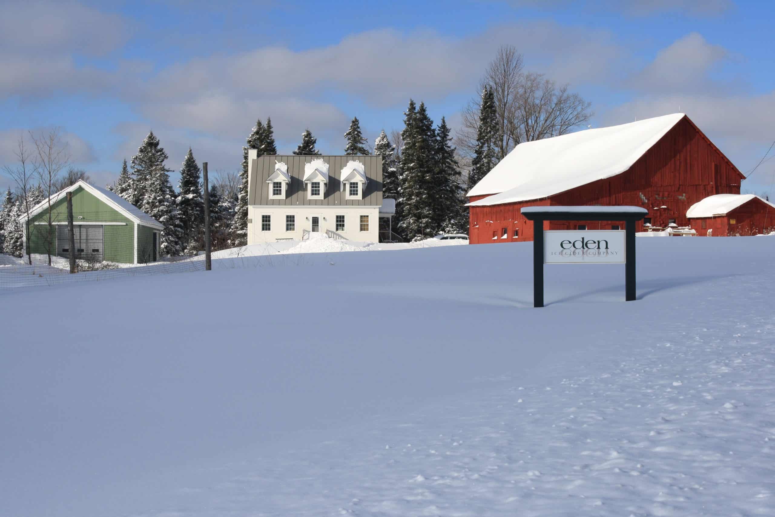 red cider barn and white house in snow